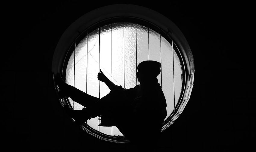 Silhouette woman sitting in window