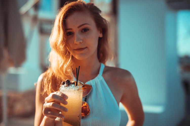 Close-up portrait of young woman holding drink