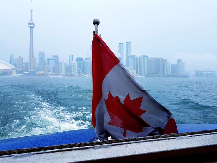 Canadian flag by lake ontario in city