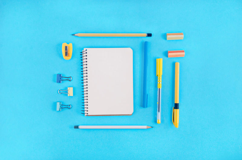 Directly above shot of school supplies over blue background
