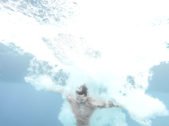 Low angle view of shirtless man swimming undersea