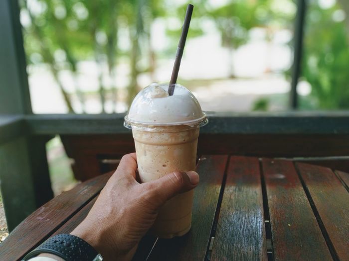 Hand holding glass of drink