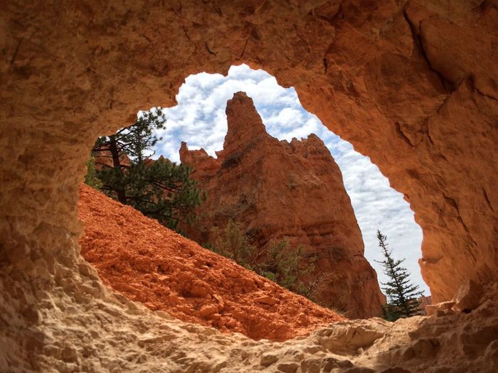 Scenic view of rock formation against sky seen through cave
