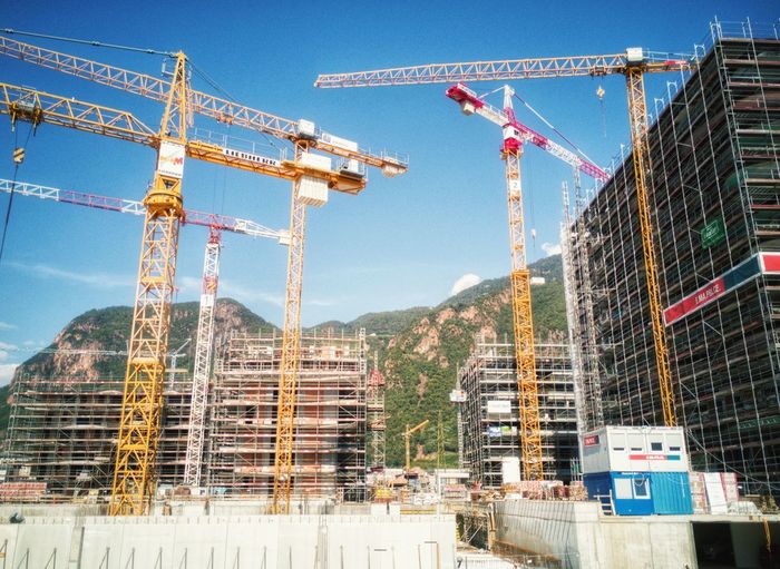 Low angle view of cranes at construction site 