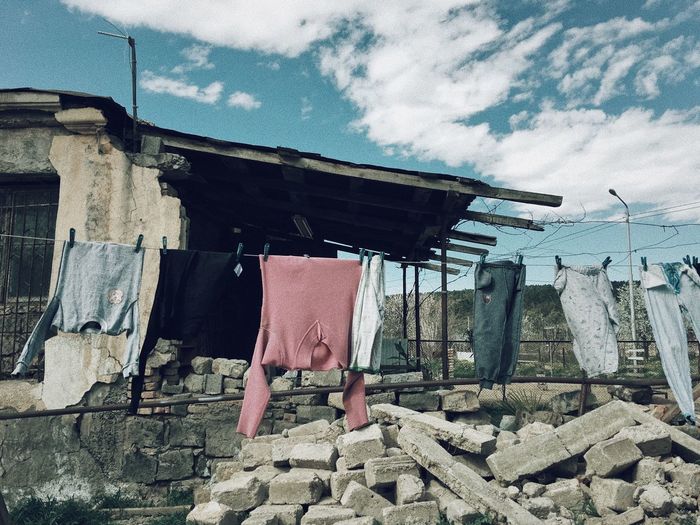Full frame shot of clothes drying outside house against sky