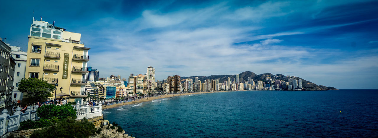 Panoramic view of sea and buildings against sky
