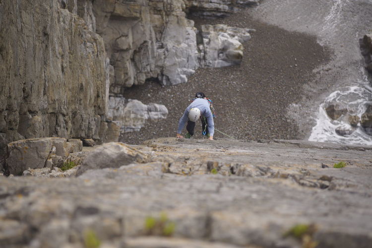 Rear view of men walking on rock