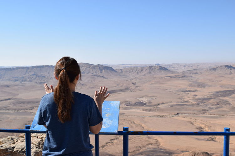 Rear view of a woman overlooking rocky landscape