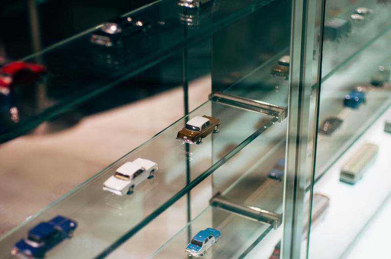 Miniature cars on glass shelf