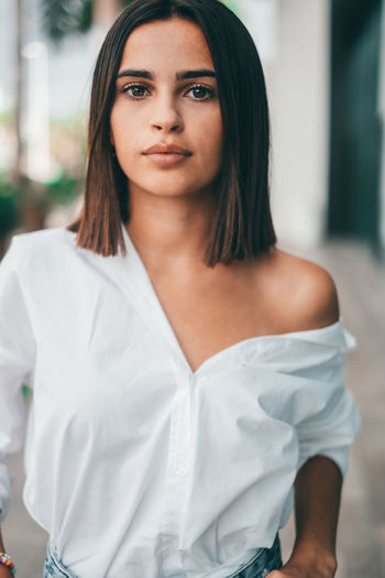 Woman with off shoulder top standing outdoors