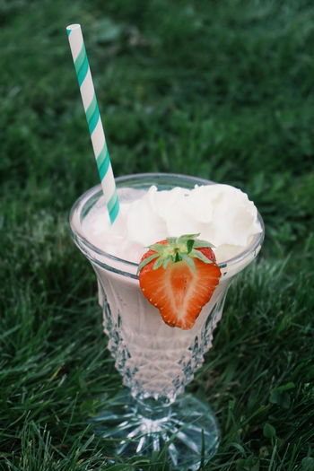 Close-up of drink with ice cream in glass on grass