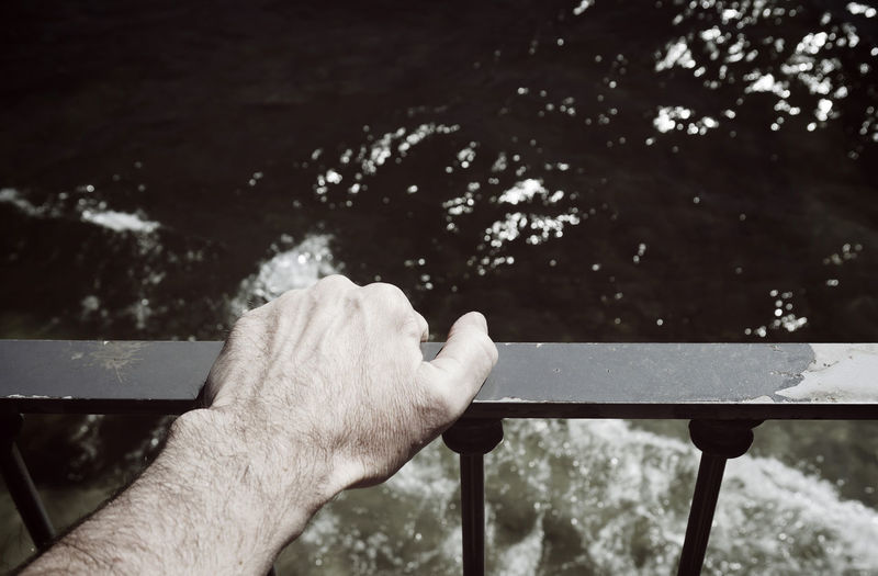 Close-up of hand holding railing
