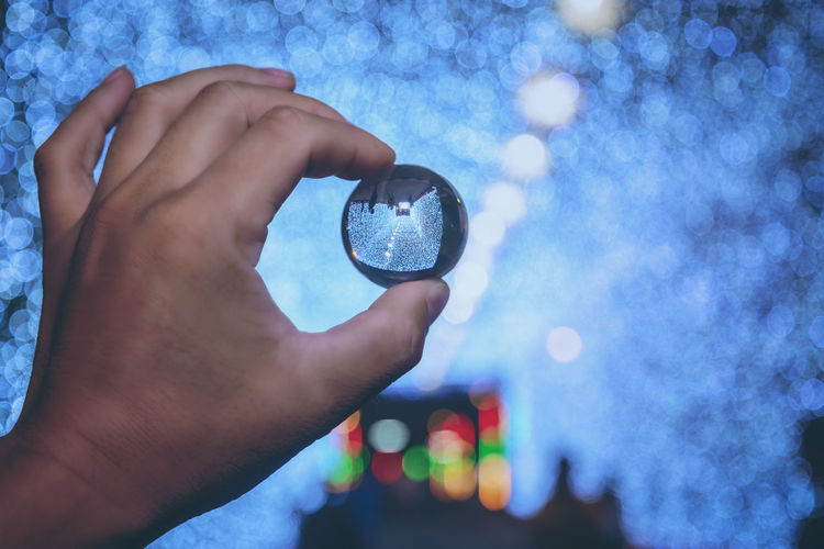 Close-up of human hand holding crystal ball