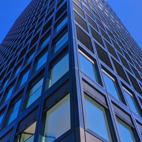 Low angle view of modern building against clear blue sky