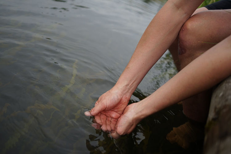 Hands dipping in river water