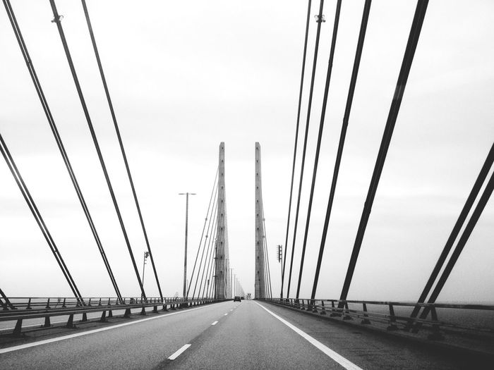 Cables and towers of bridge against sky
