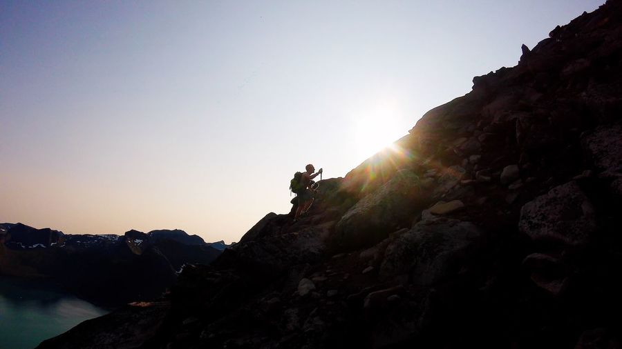 Man rock on mountain against clear sky