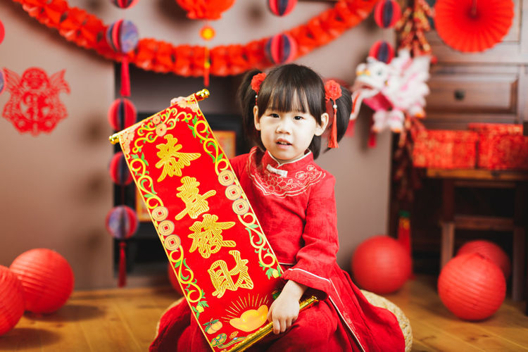 Portrait of girl in traditional clothing holding decoration
