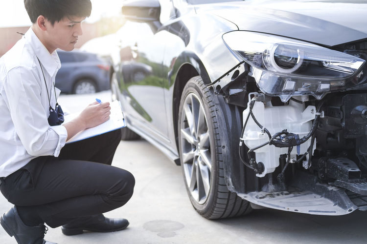 Insurance agent inspecting damaged car