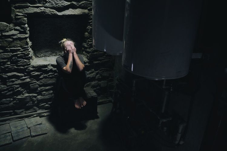 Depressed woman sitting in basement