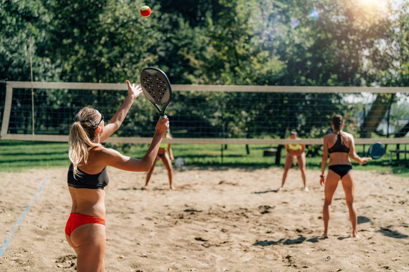 Female friends playing beach tennis