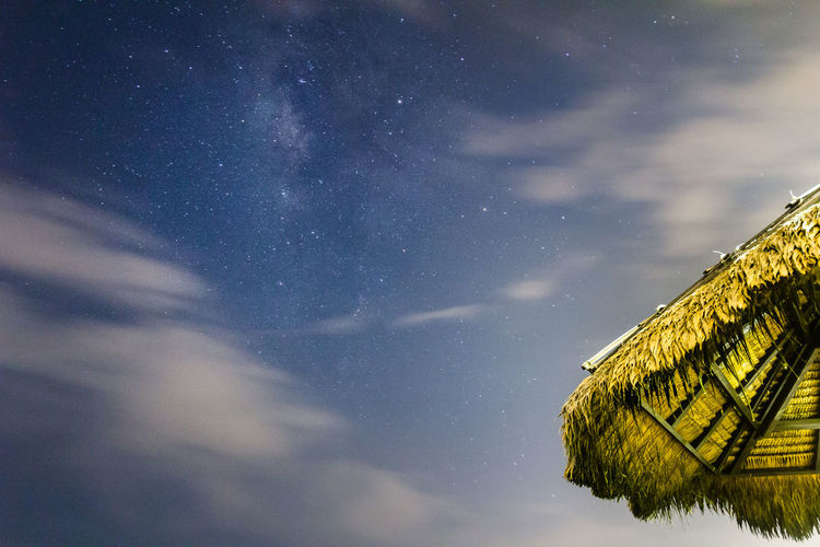 Low angle view of thatched roof against sky at night