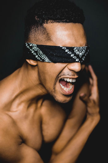 Close-up of blindfolded man screaming