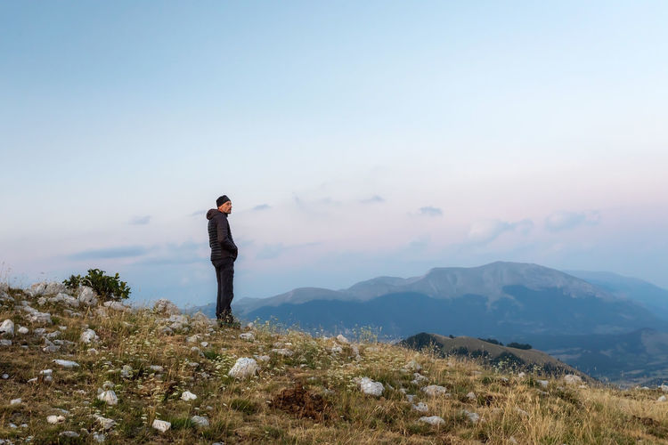 Hiker meditates amidst the mountain landscape.
