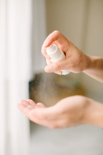 Hand spray. the woman is cleaning her hands with disinfectant spray.