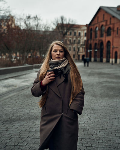 Portrait of beautiful woman standing on street in city