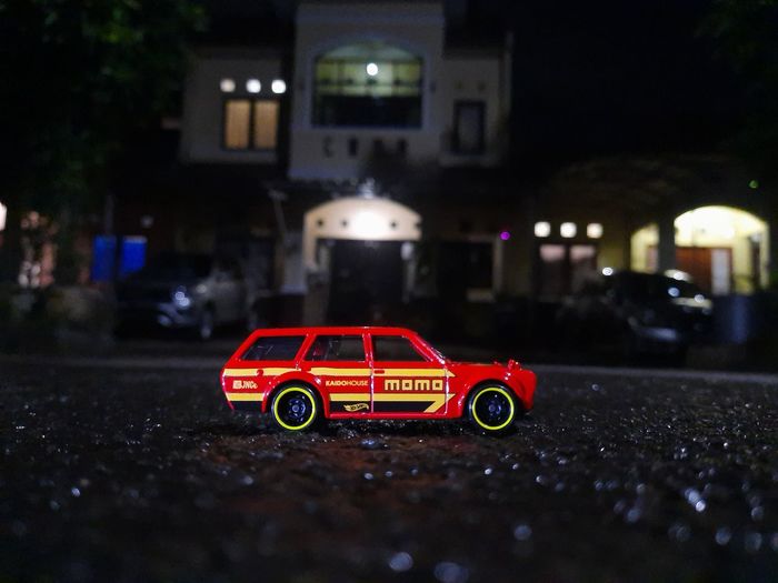 Red toy car on road at night