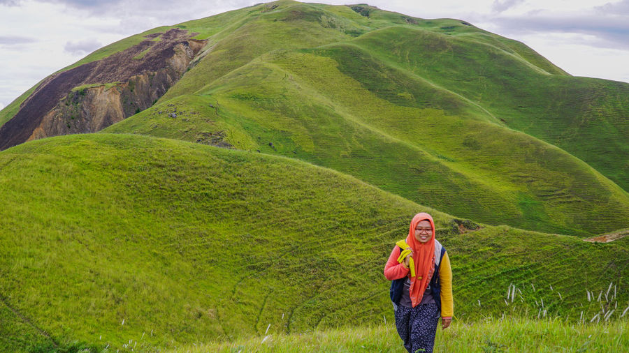 Portrait of smiling woman walking on mountain