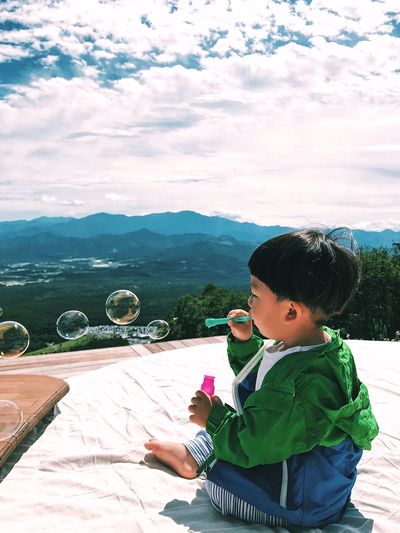 Boy on mountain against sky