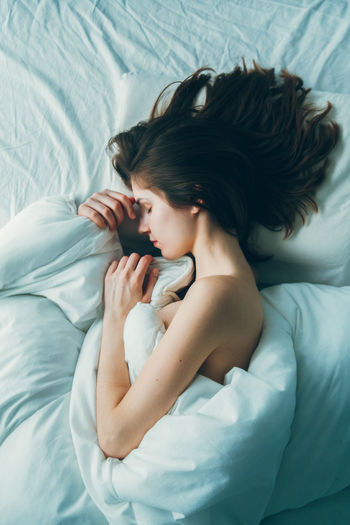 High angle view of woman lying on bed