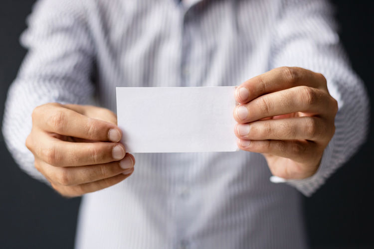 Midsection of businessman holding paper
