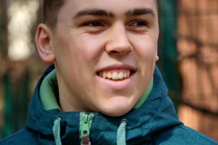 Close-up of smiling young man looking away