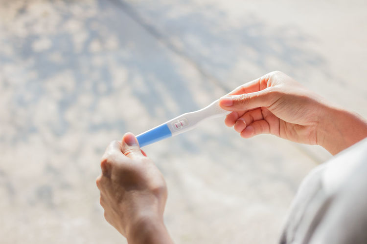 Close-up of woman holding pregnancy test equipment