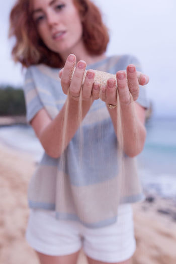 Close-up of woman with hand on beach