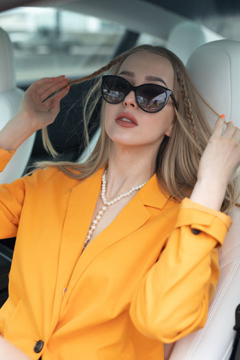 Portrait of young woman wearing sunglasses in car
