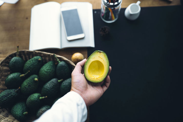 Cropped hand holding avocado