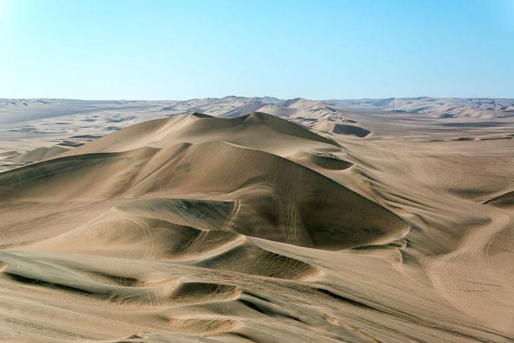 Scenic view of desert against clear blue sky at huacachina