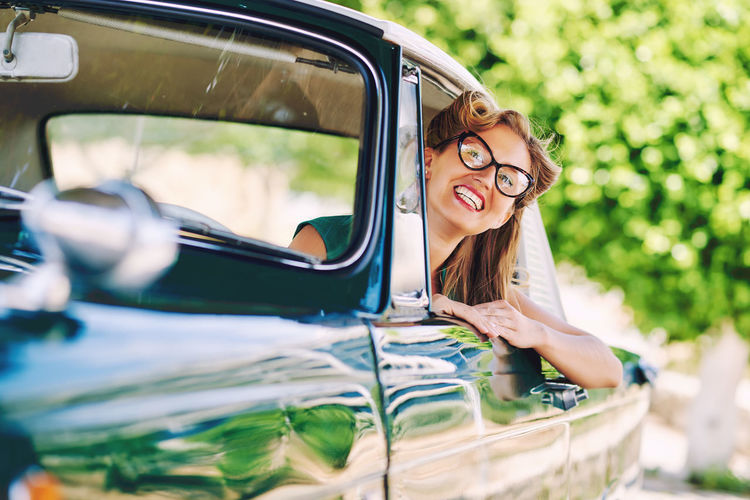 Smiling woman driving vintage car