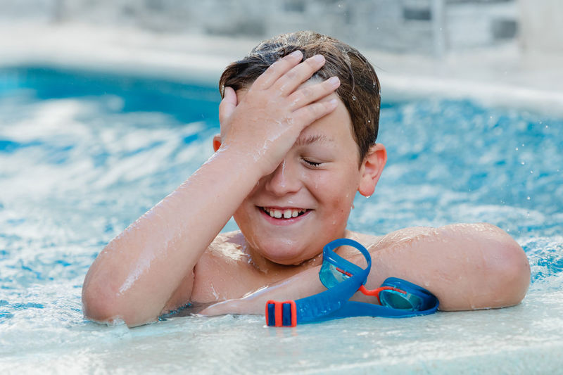 Portrait of smiling boy swimming in pool