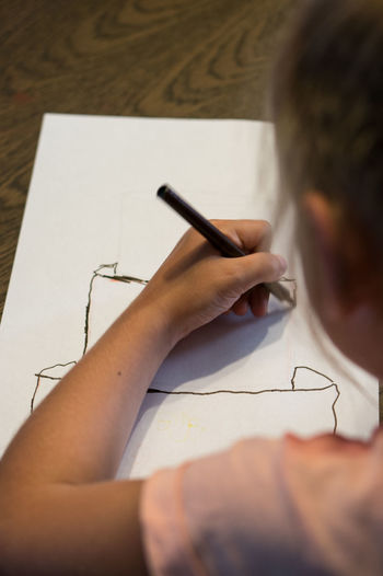 Close-up of girl drawing on paper at home