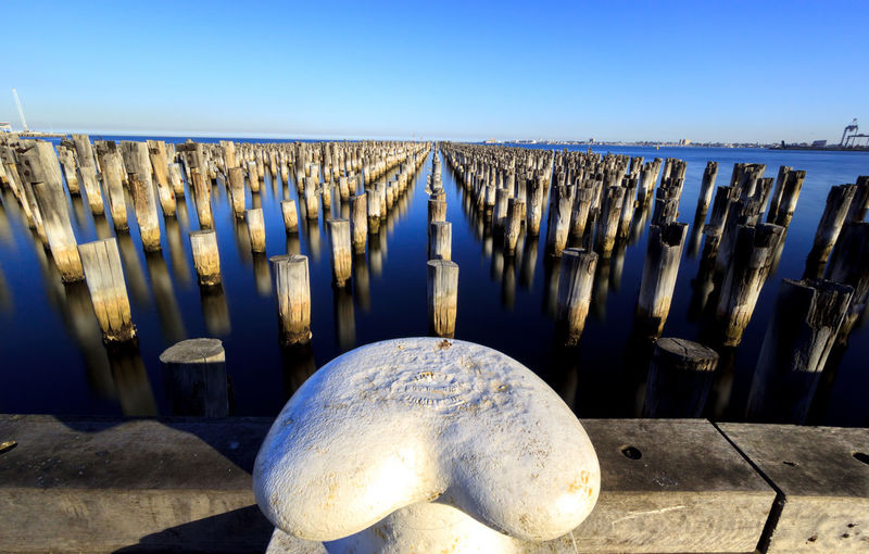 Metal mooring with wooden posts of princes pier in the harbour on a sunny blue sky day