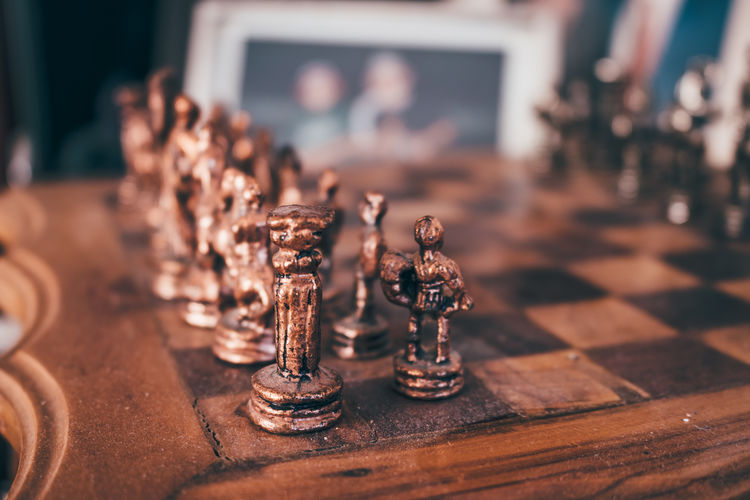 Old vintage wooden chessboard with brass pieces. selective focus, close up.
