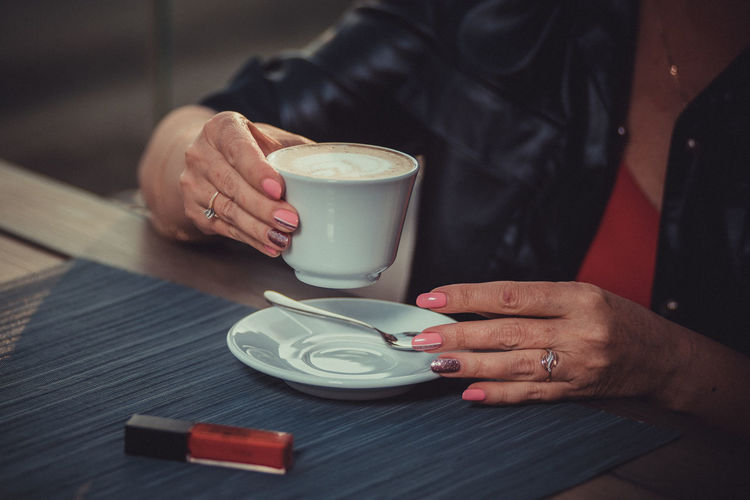 Woman is about to drink a cappuccino