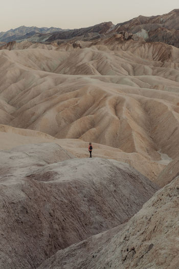 Distant view of woman standing at desert