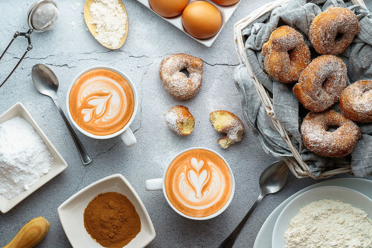 Coffee with latte art and small doughnut of wine with sugar and cinnamon and ingredients. donuts dessert