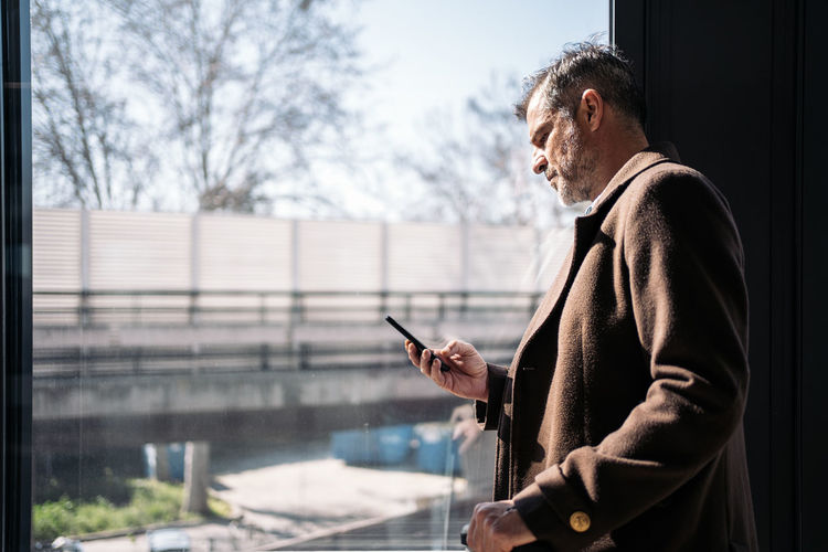 Side view of man using mobile phone